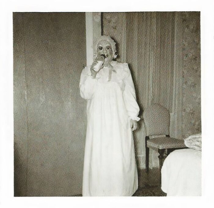 Vintage Halloween costume from the past featuring a haunting figure in a nightgown and mask, capturing terrifying and impressive style.