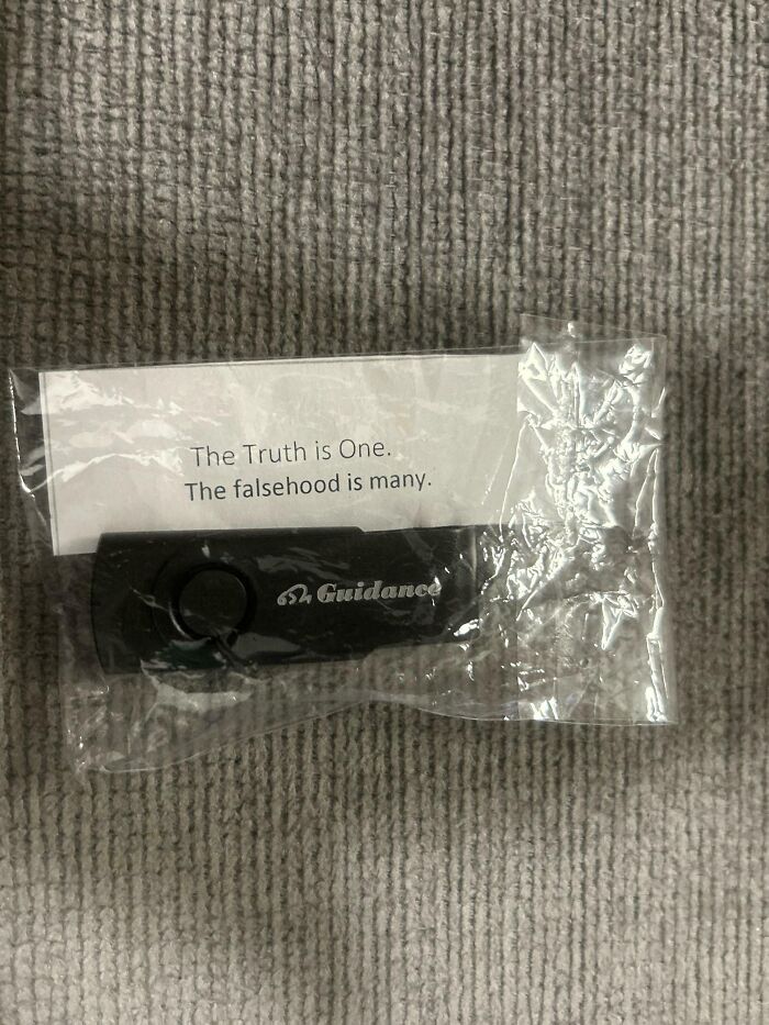 A USB flash drive in plastic packaging with a fortune slip reading the truth is one, the falsehood is many.