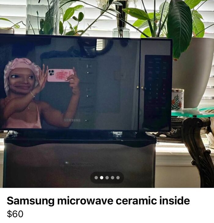 Reflection of person taking selfie in a microwave screen, illustrating funny mirror selling moments with reflections that sold it