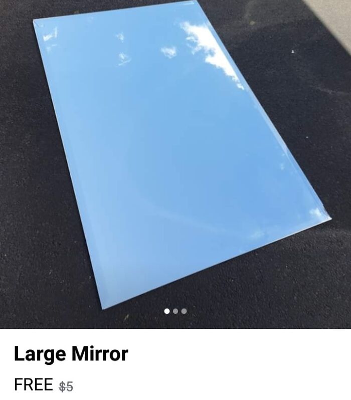 Large mirror on pavement reflecting blue sky and clouds, showing hilarious times people sold mirrors with reflections.
