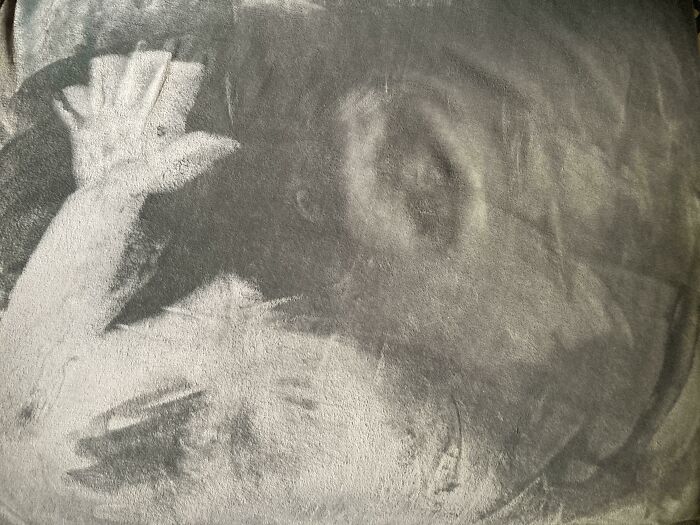 Shadowy hand and face imprint on a dusty surface, illustrating a total mess and unexpected worse situations.