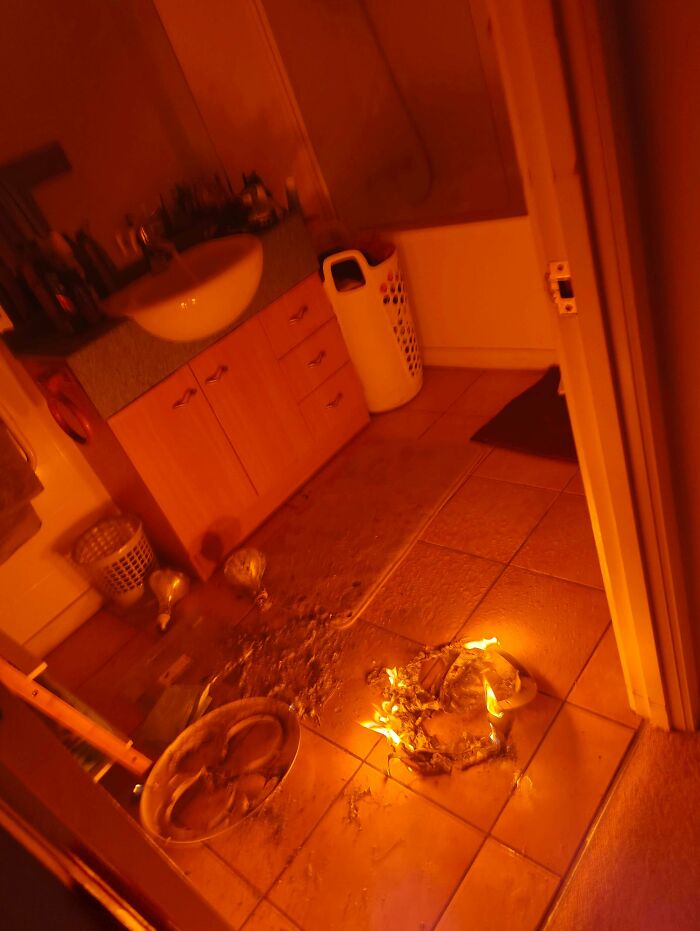 Bathroom with a small fire on the tiled floor, showing a chaotic and messy scene to remind it can always get worse.
