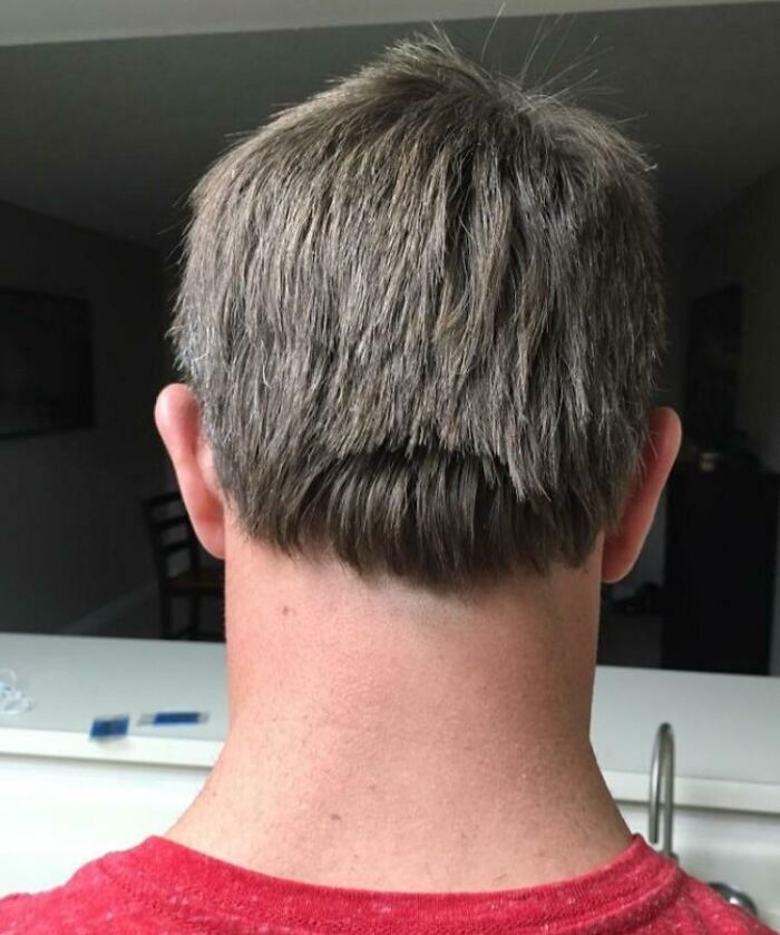 Man with a hilariously tragic hair accident, showing an uneven and awkward haircut from the back.