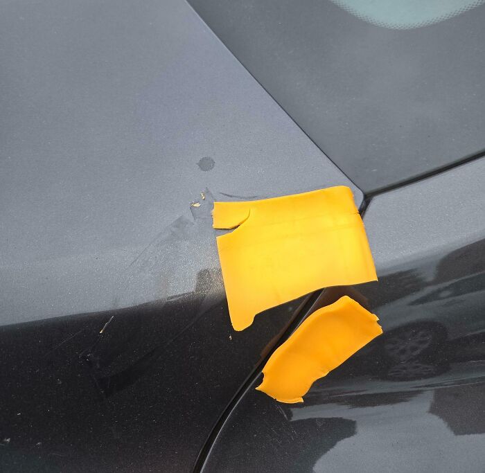Damaged black car with peeling yellow tape, illustrating a total mess to remind you it can always get worse.