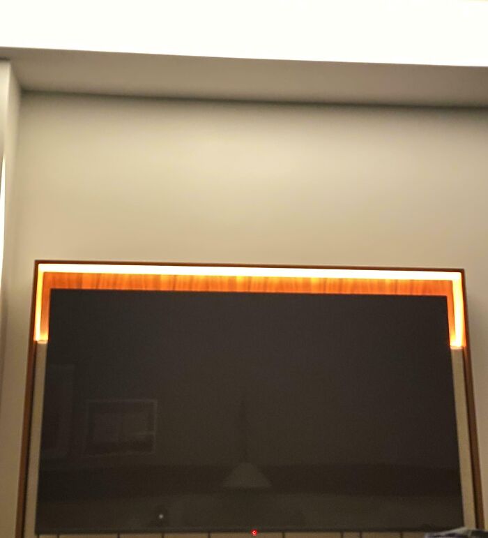 Modern TV mounted on wall with uneven lighting, showing a reminder that today can always get worse in moments.