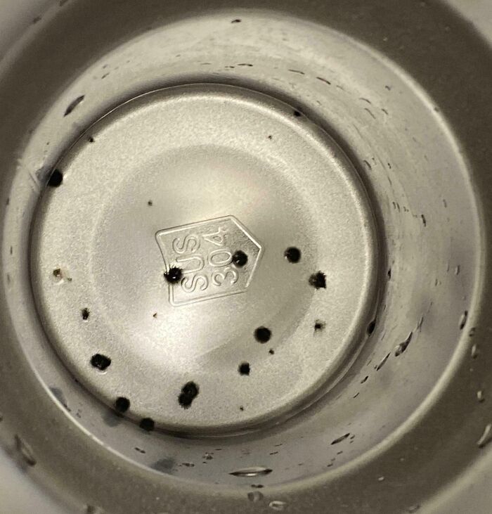 Close-up of a dirty metal container interior with black grime spots, showing a total mess condition reminder.