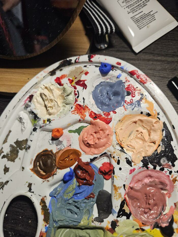 Artist's paint palette with mixed colors used for hand-painted Vincent van Gogh Halloween makeup and costume creation.