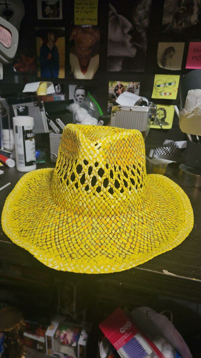 Yellow hand-painted woven hat on a table as part of an artist's costume for Vincent van Gogh Halloween transformation.