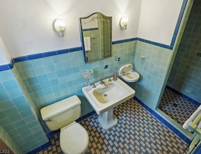 Vintage bathroom in a charming old home featuring blue tile walls, a pedestal sink, and classic fixtures.