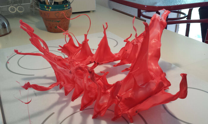 Red paint splash frozen mid-air over a white surface, illustrating an interesting pic that answers unexpected questions.