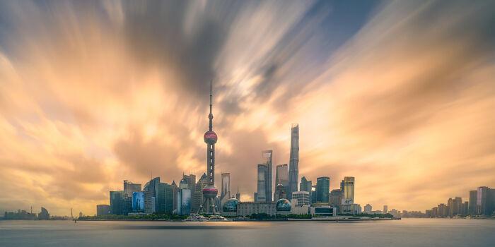 Panoramic cityscape of Shanghai skyline at sunset with dramatic clouds, showcasing award-winning panoramic photography.