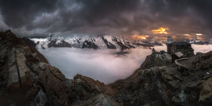 Panoramic masterpiece of a dramatic mountain landscape with clouds and a sunset, winning the Epson Pano Awards 2025.