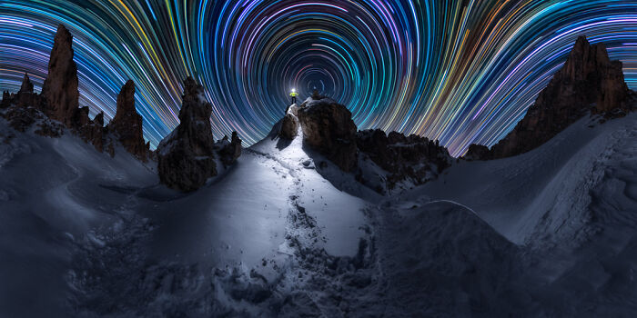 Panoramic night sky with star trails above snowy rocky landscape, showcasing stunning Epson Pano Awards winning photography.