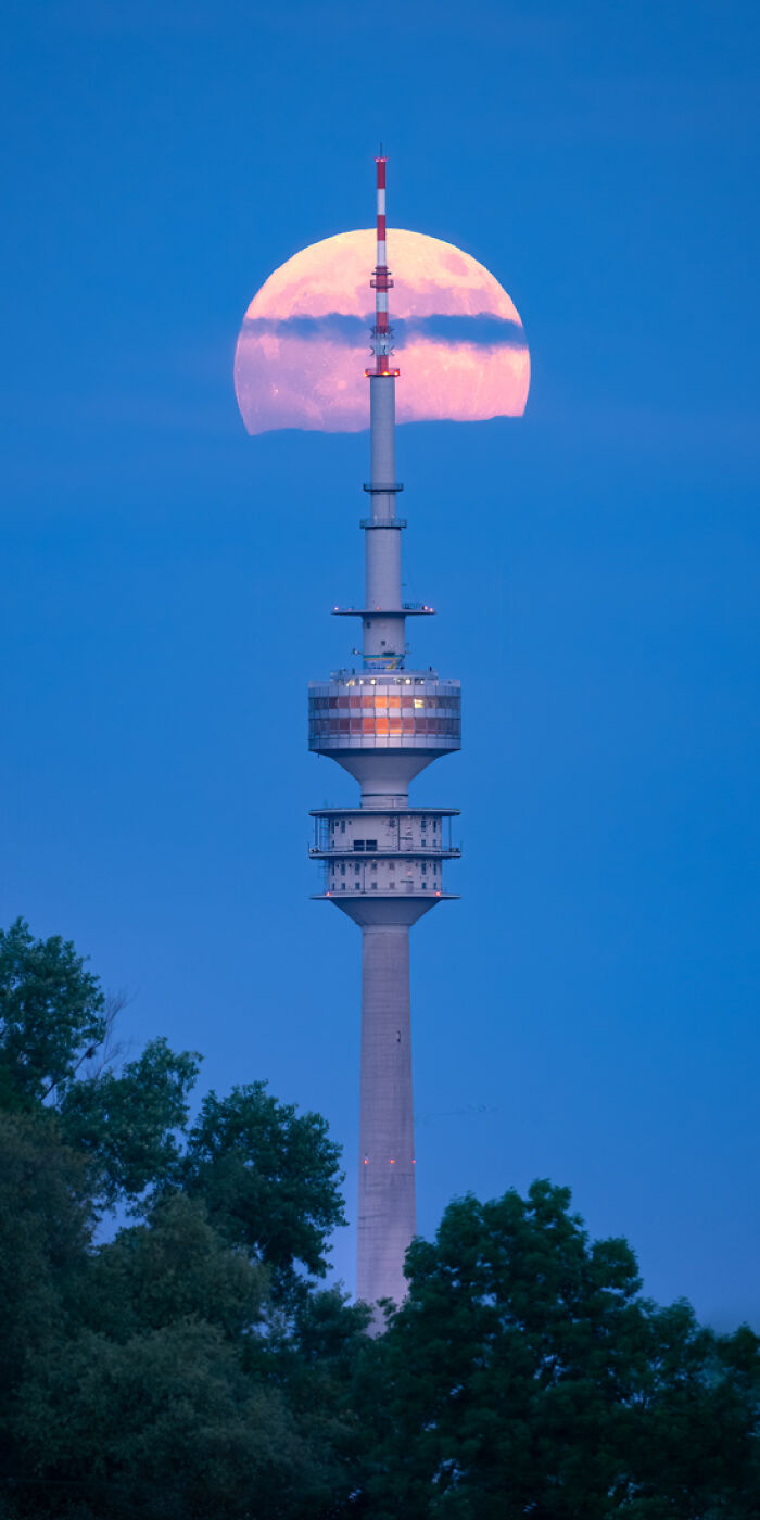 Tall communication tower framed by a large glowing moon at dusk, highlighting panoramic masterpieces from the Epson Pano Awards.