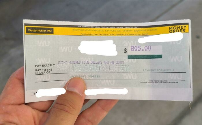 Hand holding a Western Union money order for $805, illustrating acts of kindness and strangers helping each other.