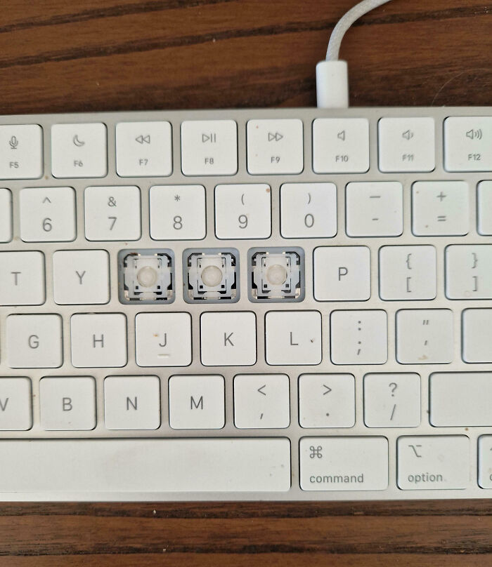 White keyboard with three missing keys showing the internal mechanisms, illustrating a total mess moment.