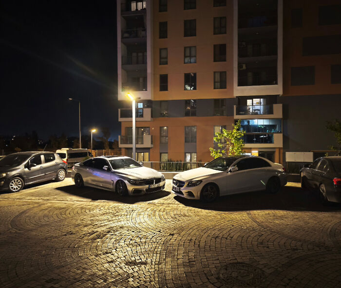 Nighttime parking lot with several cars under streetlights, illustrating a total mess and how it can always get worse.