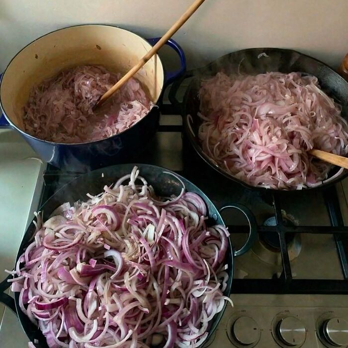 Three pots filled with sliced onions on a stove, creating a scene that might need a priest or an exorcist.