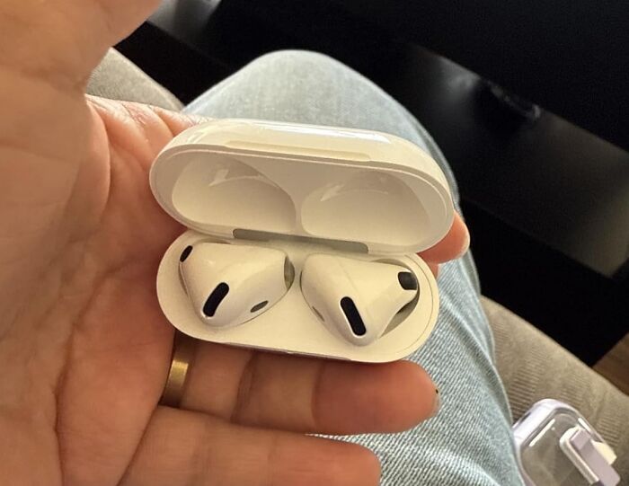 White wireless earbuds in charging case held in hand, one of the viral products from Amazon's big deal days.