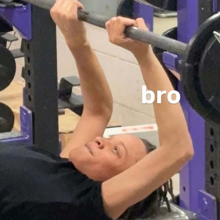 Person struggling to lift heavy barbell in gym, an image that might need a priest or an exorcist vibe.