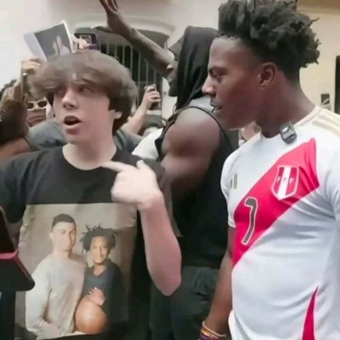 Group of people in casual clothing, one person pointing while others look on, odd scene that might need an exorcist.