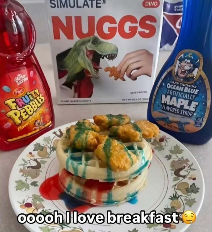 Waffle stacked with dinosaur-shaped chicken nuggets and colorful Fruity Pebbles and maple syrup on a plate, playful food setup.