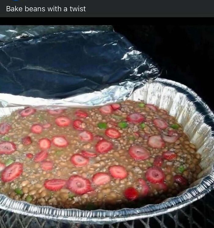Baked beans with sliced strawberries and green peppers in a foil pan, a strange combination that might need a priest or exorcist.