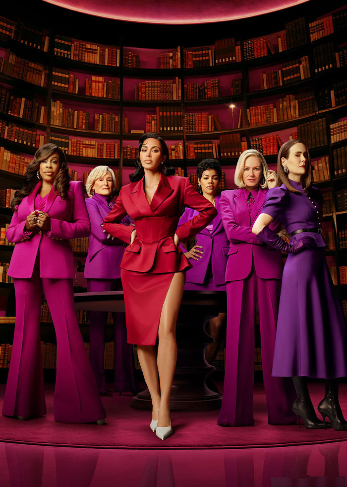Naomi Watts and Sarah Paulson posing confidently in bold braless outfits at a library setting with Kim Kardashian.