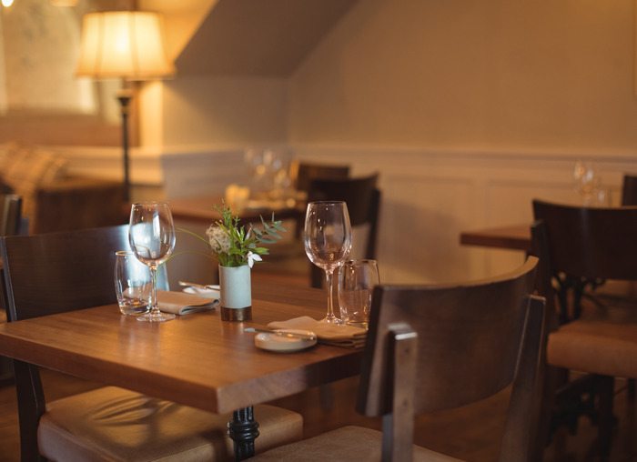 Empty restaurant table set with glassware and napkins, conveying an unexpected and awkward dining atmosphere.