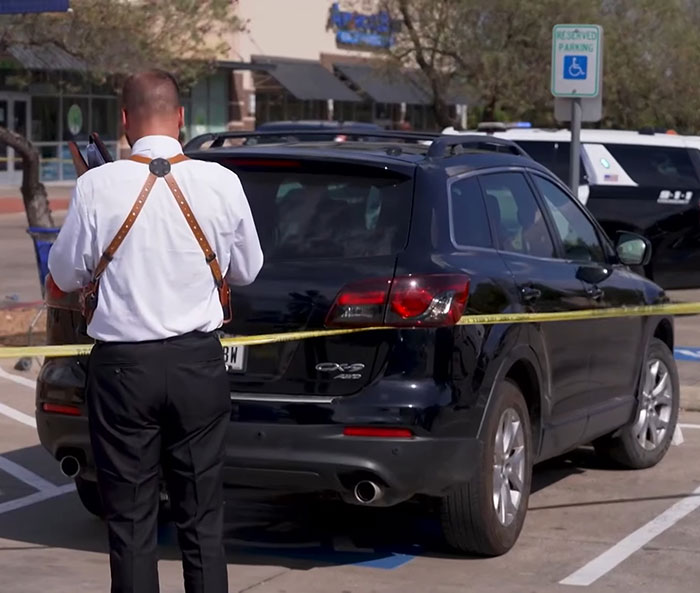 Man in white shirt and suspenders stands near police tape outside pet store after woman loses life incident.