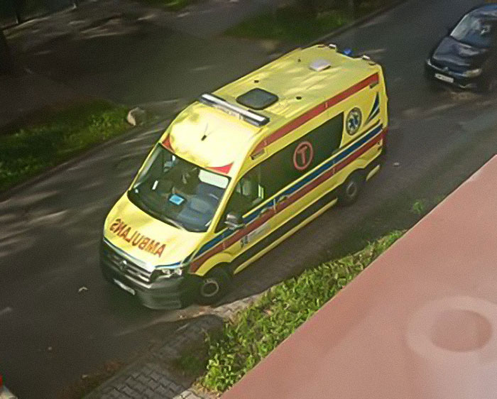 Yellow ambulance parked on a street, related to the woman emaciated after being missing for 27 years story.