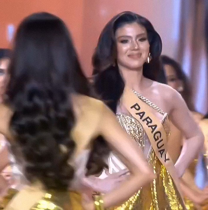 Miss Panama onstage in a gold dress wearing a sash, experiencing a painfully awkward moment during a beauty pageant event.