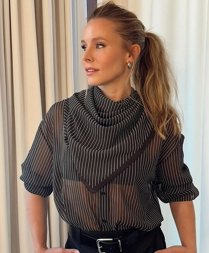 Kristen Bell wearing a striped black sheer blouse and ponytail, looking to the side amid expert backlash and triggering post controversy.