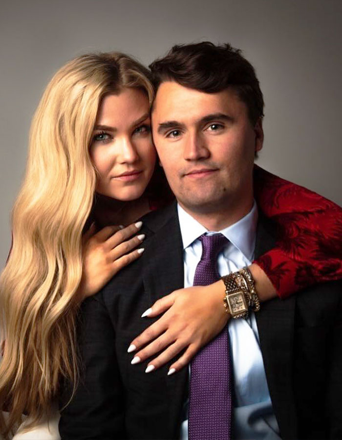 Woman with long blonde hair embraces man in suit and purple tie, related to teacher of the year finalist controversy.