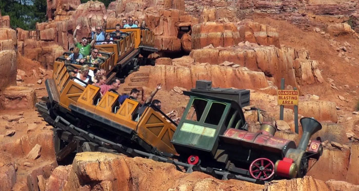 Roller coaster ride at Disney World with visitors on a mountain-themed track, highlighting tragic incidents at the park.