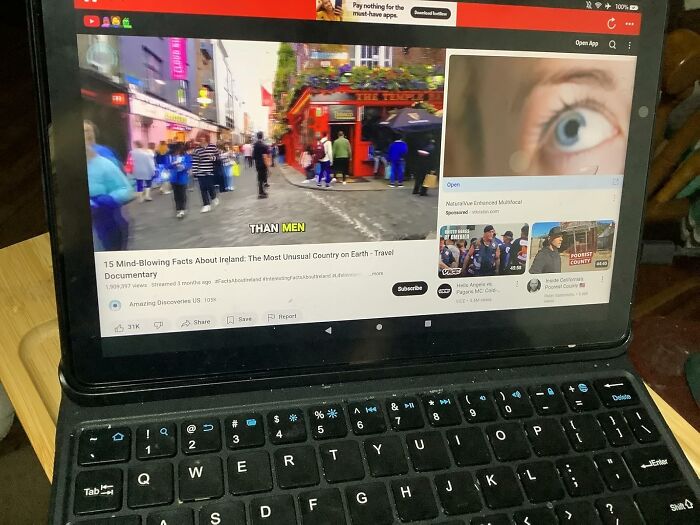 Tablet with keyboard showing viral products video on Amazon’s Big Deal Days alongside a busy street scene.