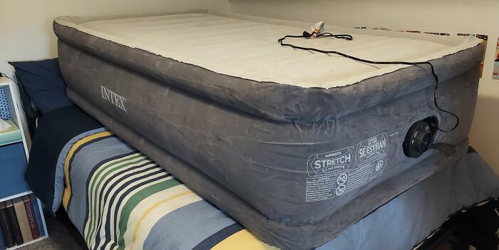 Inflatable airbed mattress on striped bed, a popular viral product bought during Amazon Big Deal Days.