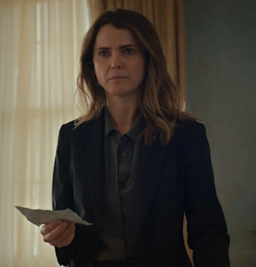 Keri Russell, 49, with serious expression indoors, highlighting Hollywood's growing plastic surgery trend for women.