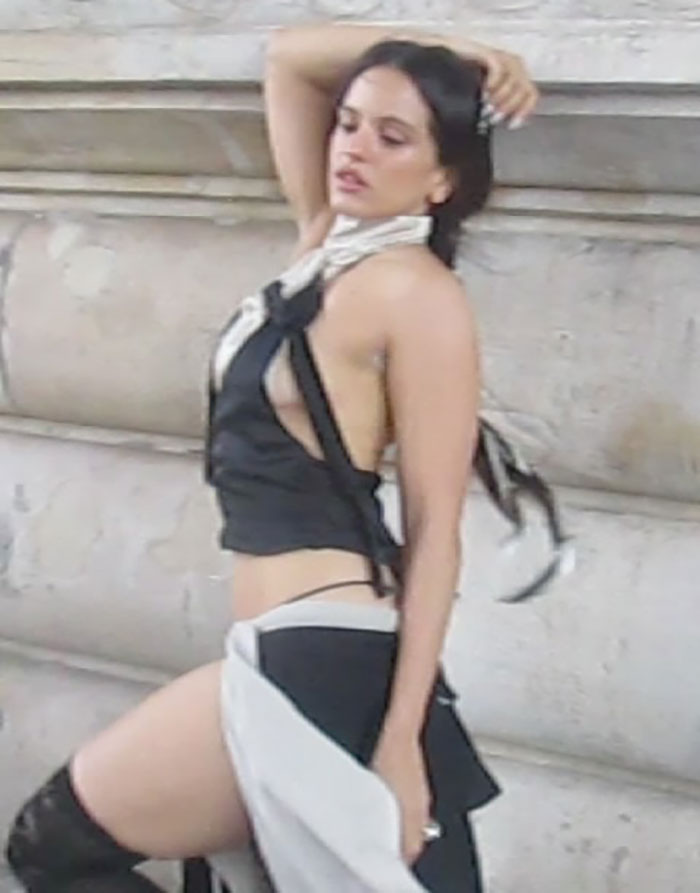 Pop star posing at Paris Fashion Week showing dyed armpit hair and unique black and white outfit.