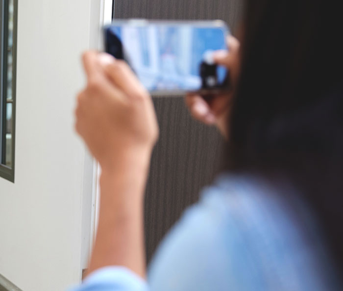Person taking a photo with smartphone in a home setting related to 12-year-old escaping severe mistreatment case