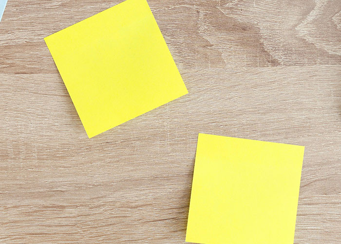 Two yellow sticky notes placed on a wooden desk representing ideas to use loopholes against horrible bosses.