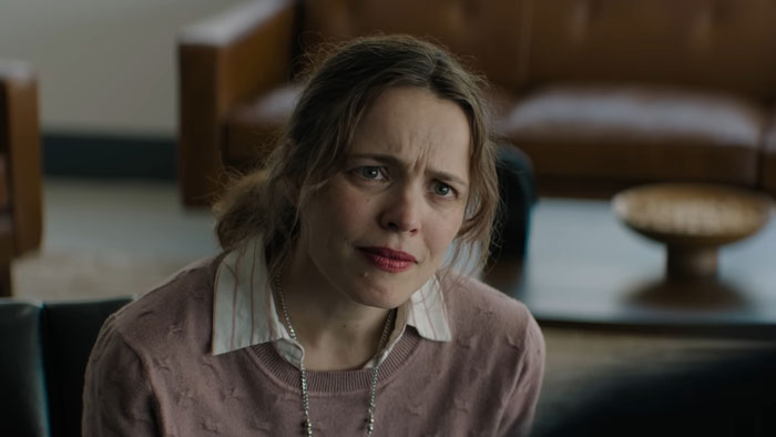 Rachel Mcadams with a natural look, wearing a pink sweater and white collared shirt in a film scene indoors. Rachel Mcadams with a natural look, wearing a pink sweater and white collared shirt in a film scene indoors.