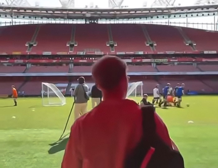 Young man with leg amputation watching a sports field, sharing his story after attending a rock concert incident.