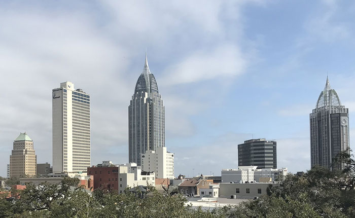City skyline with tall buildings under a cloudy sky, illustrating places people wouldn’t revisit even if paid.