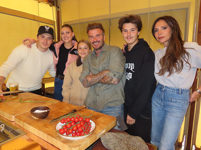 Victoria Beckham and family including Brooklyn's wife Nicola Peltz in a casual group photo in a kitchen setting.