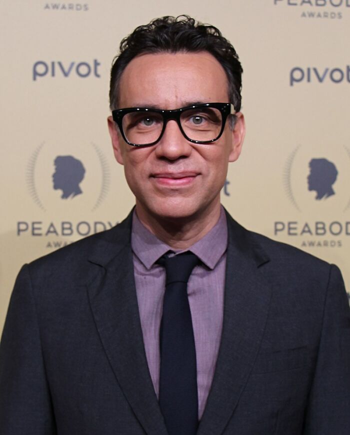 Man in glasses and suit at Peabody Awards, representing celebs people can't stand even though many love them.