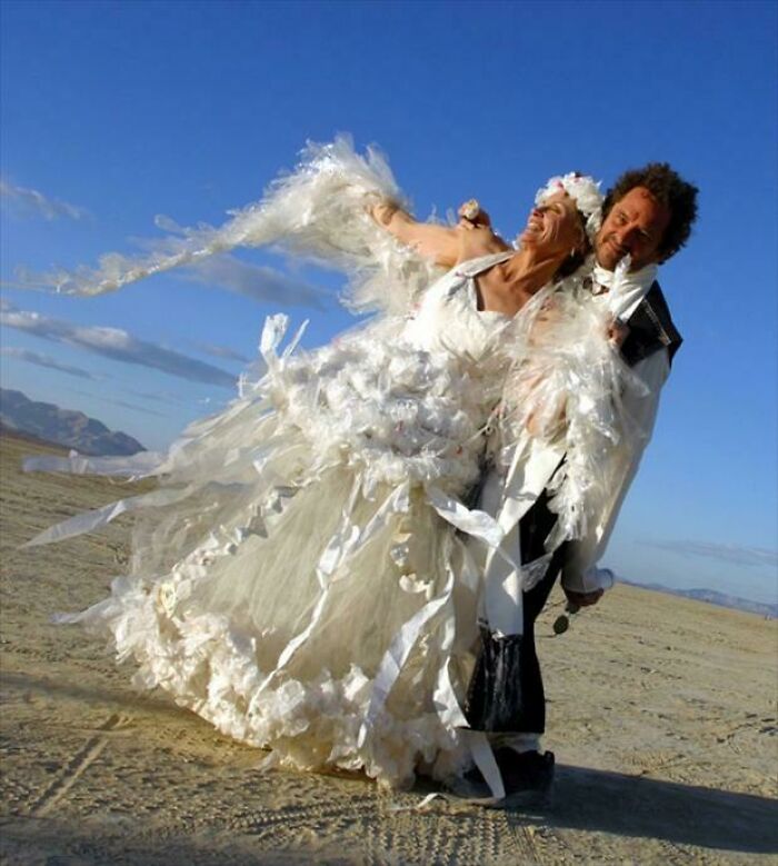 Bride and groom outdoors with the bride wearing a wedding dress featuring unusual and questionable design elements.