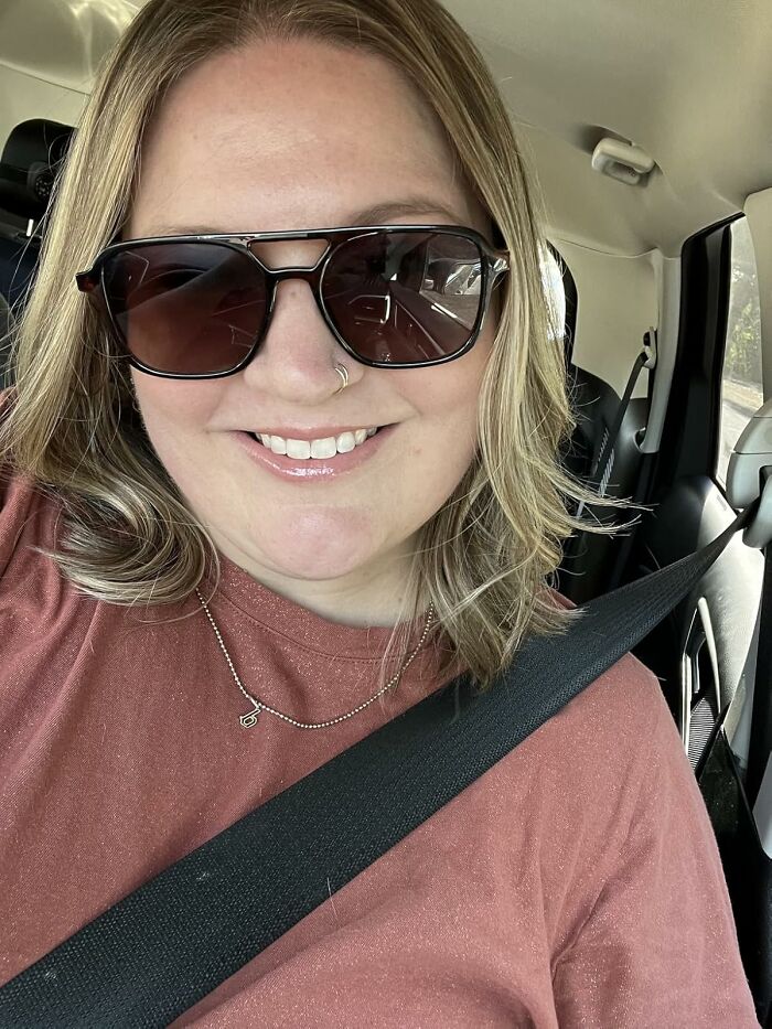 Woman wearing sunglasses and rust-colored shirt smiling inside a car showcasing viral products from Amazon’s big deal days.