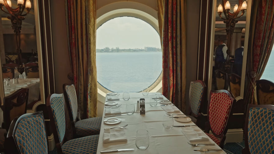Dining area on a Disney cruise ship with ocean view through a porthole, related to girl's terrifying plunge incident.
