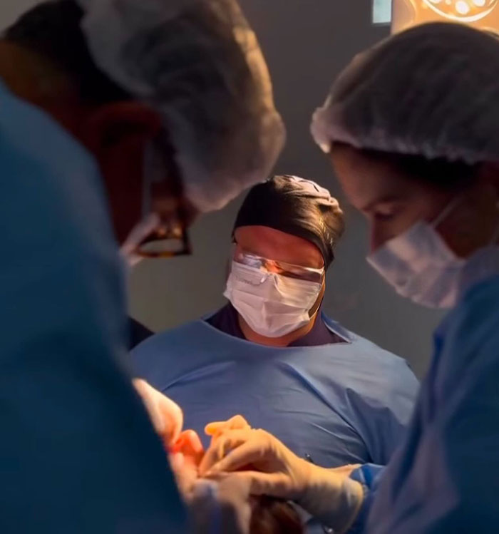 Medical team performing surgery in an operating room, highlighting complications from popular fox eyes cosmetic procedure.